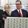 Treasury Secretary Steven Mnuchin, right, and his wife Louise Linton, hold up a sheet of new $1 bills.