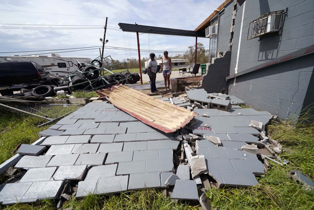 Monique Benjamin and her daughter Amiah Winbush look at the damage to their car detailing business in the aftermath of Hurricane Laura.