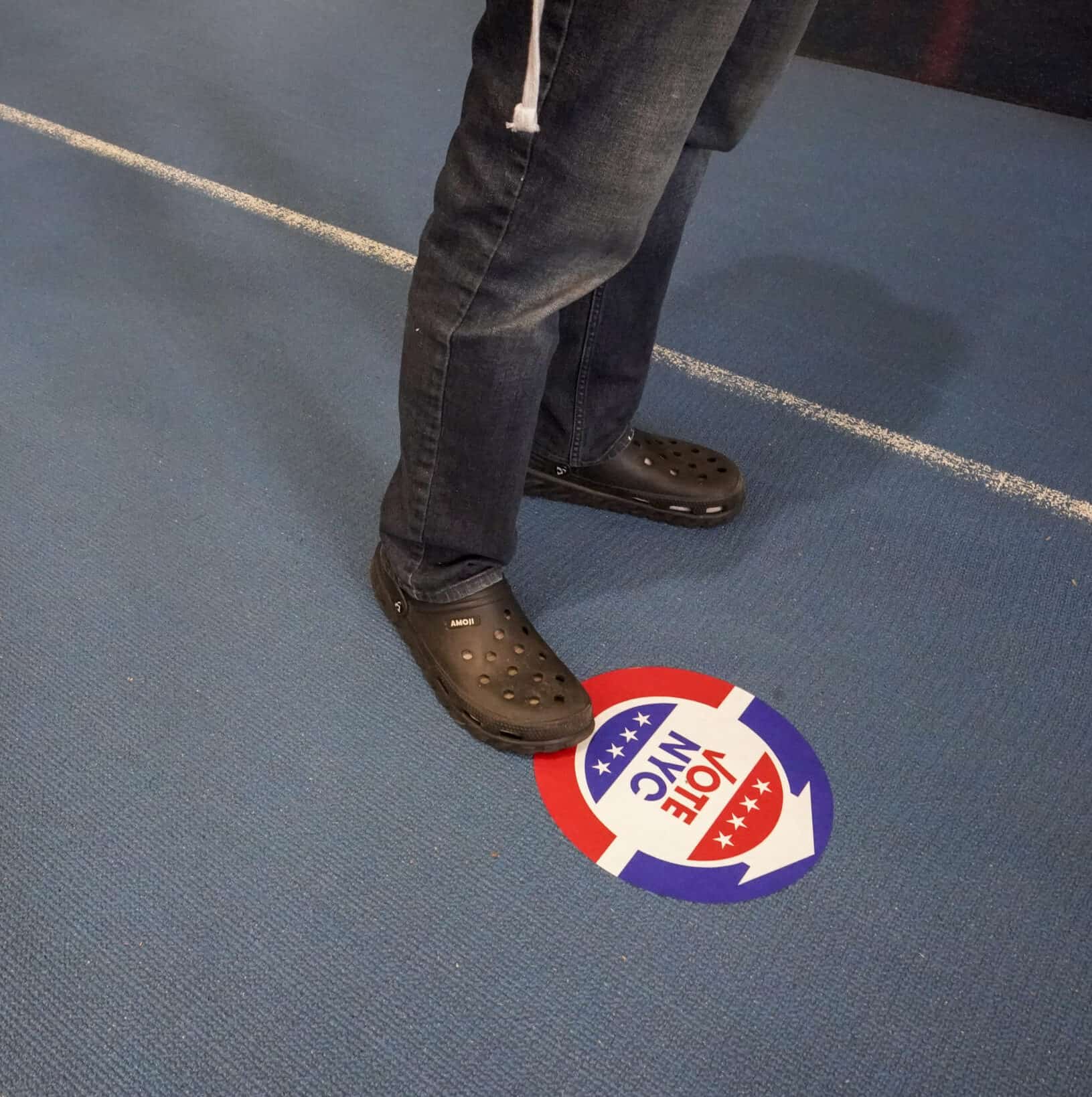 Voters stand six feet apart while waiting to vote early
