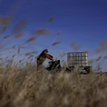 Rod Bradshaw, a Black farmer, tries to start an air compressor as he does chores on his farm near Jetmore, Kansas.