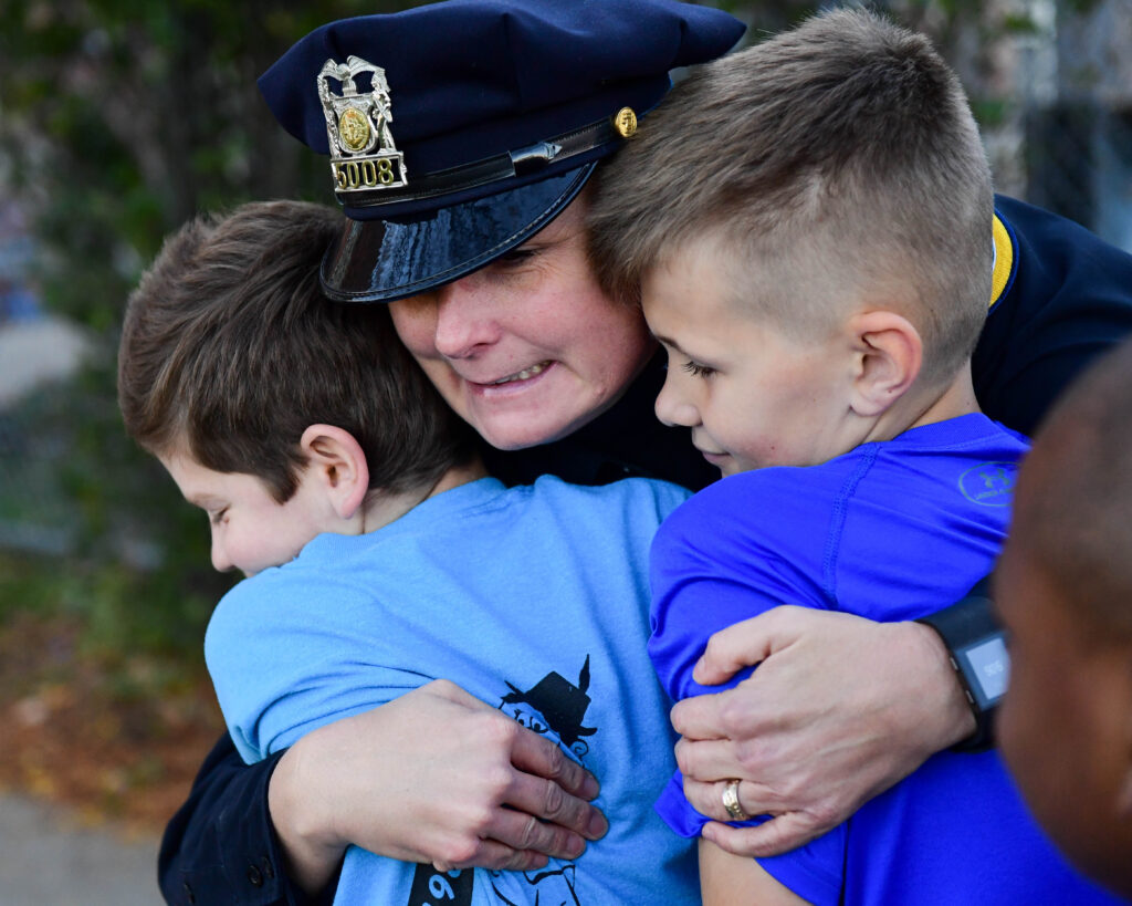 Officer Deborah VanVelzen give hugs two at a time at Hubbell Elementary School in 2016. 