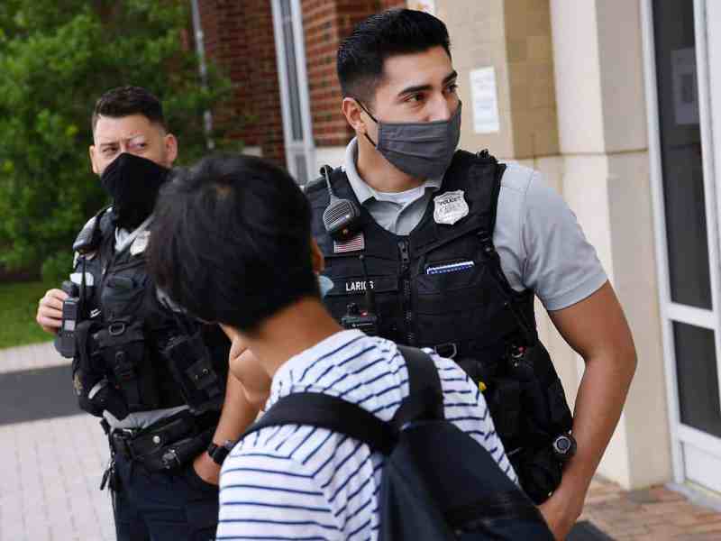 Alexandria Police Department school safety officers talk to a student at T.C. Williams High School.