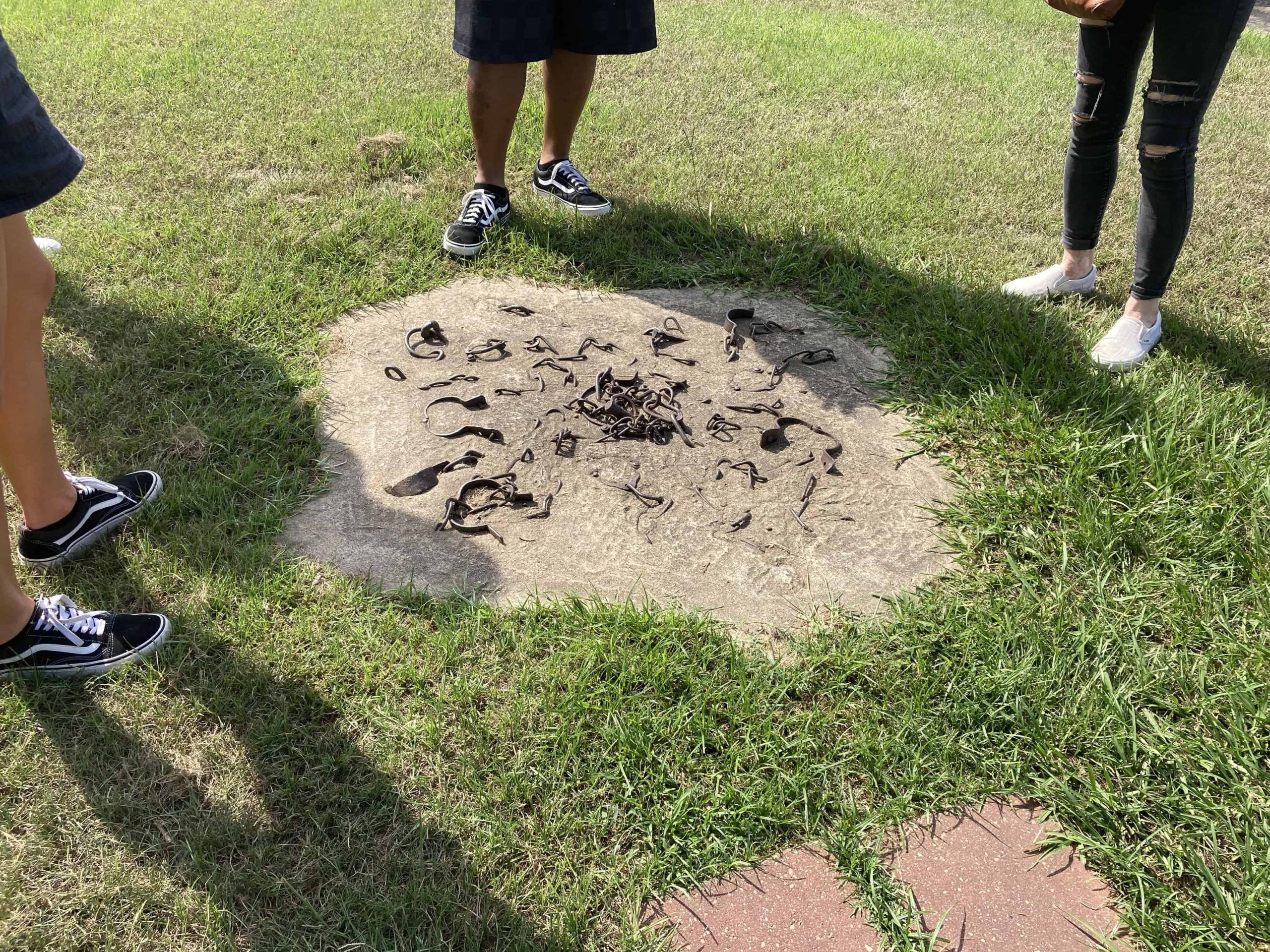 Tourists stand around chains and shackles placed in concrete. Mississippi did not expand Medicaid.