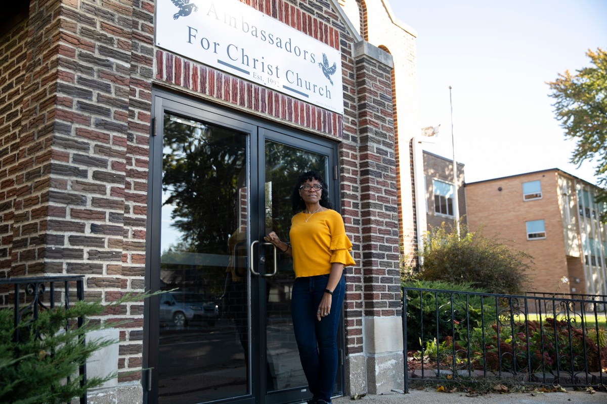 ReShonda Young stands at the double doors outside a church property in Waterloo, Iowa, that she's hoping to purchase.