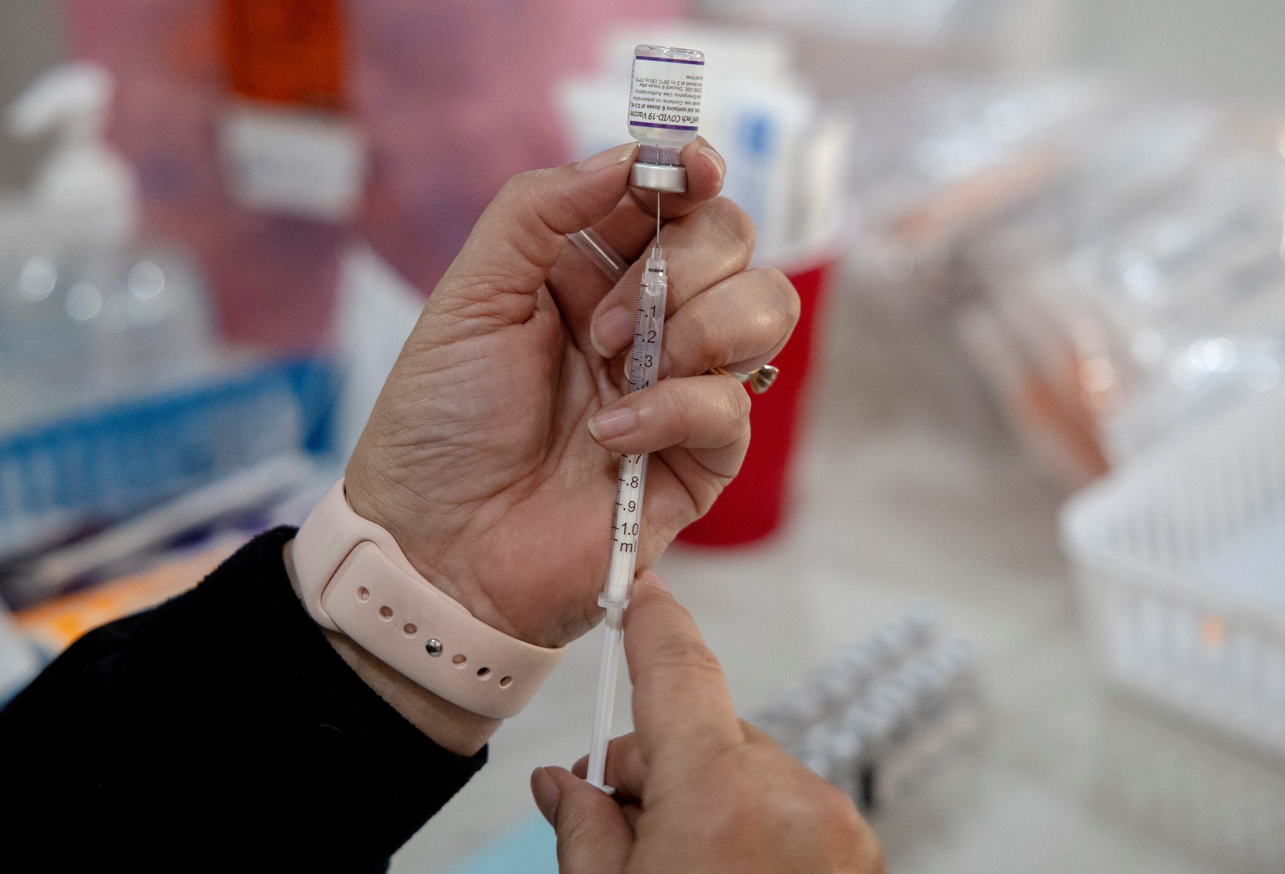 A medical staff member prepares a syringe with a dose of COVID vaccine.