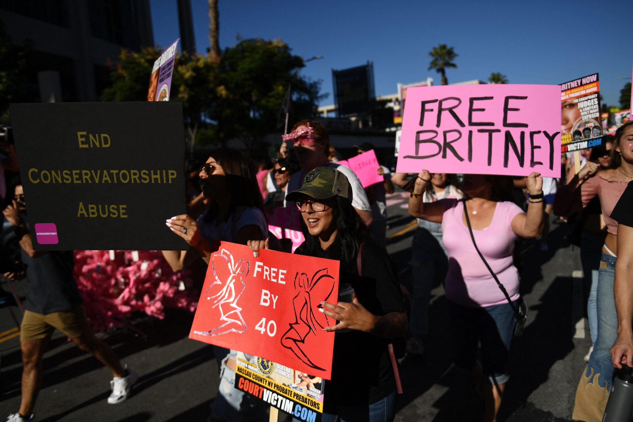 Britney Spears supporters hold up signs saying "Free Britney" and "End Conservatorship Abuse".