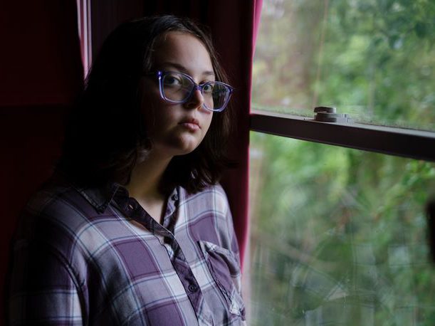 Latha Wright stands beside a window.