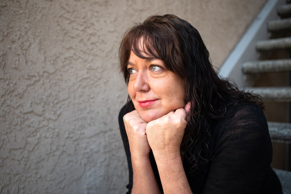 Beth Petersen sits on the steps outside her apartment after waiting for her son to catch the school bus
