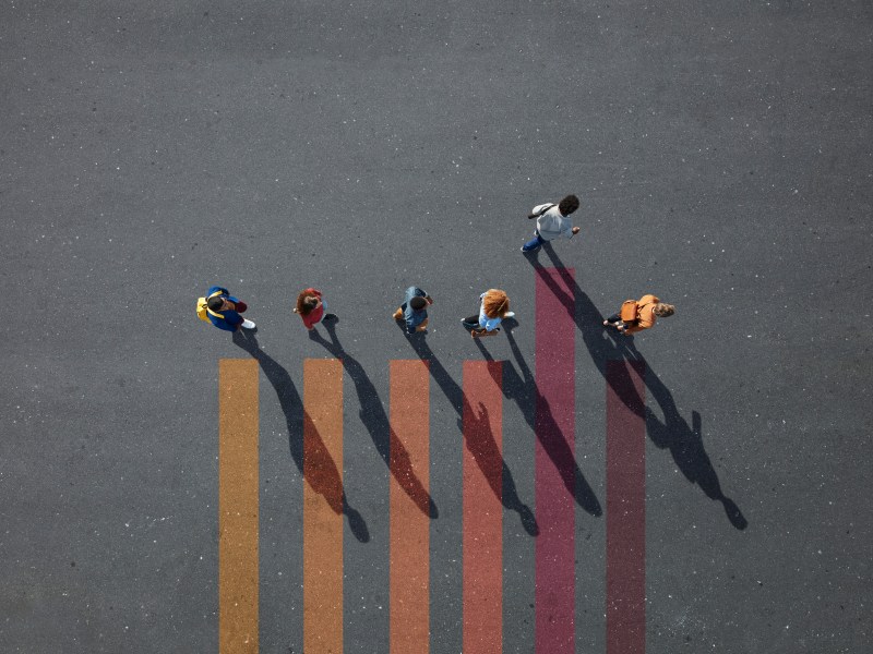 Group of young adults, photographed from above, on various painted tarmac surface, at sunrise.