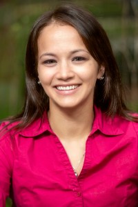 Christine Herman has long brown hair and is wearing a pink blouse.