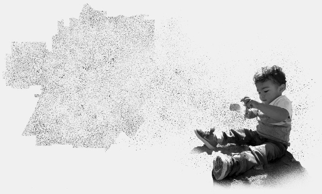 A baby plays with a toy as he sits next to a map of a section of California.