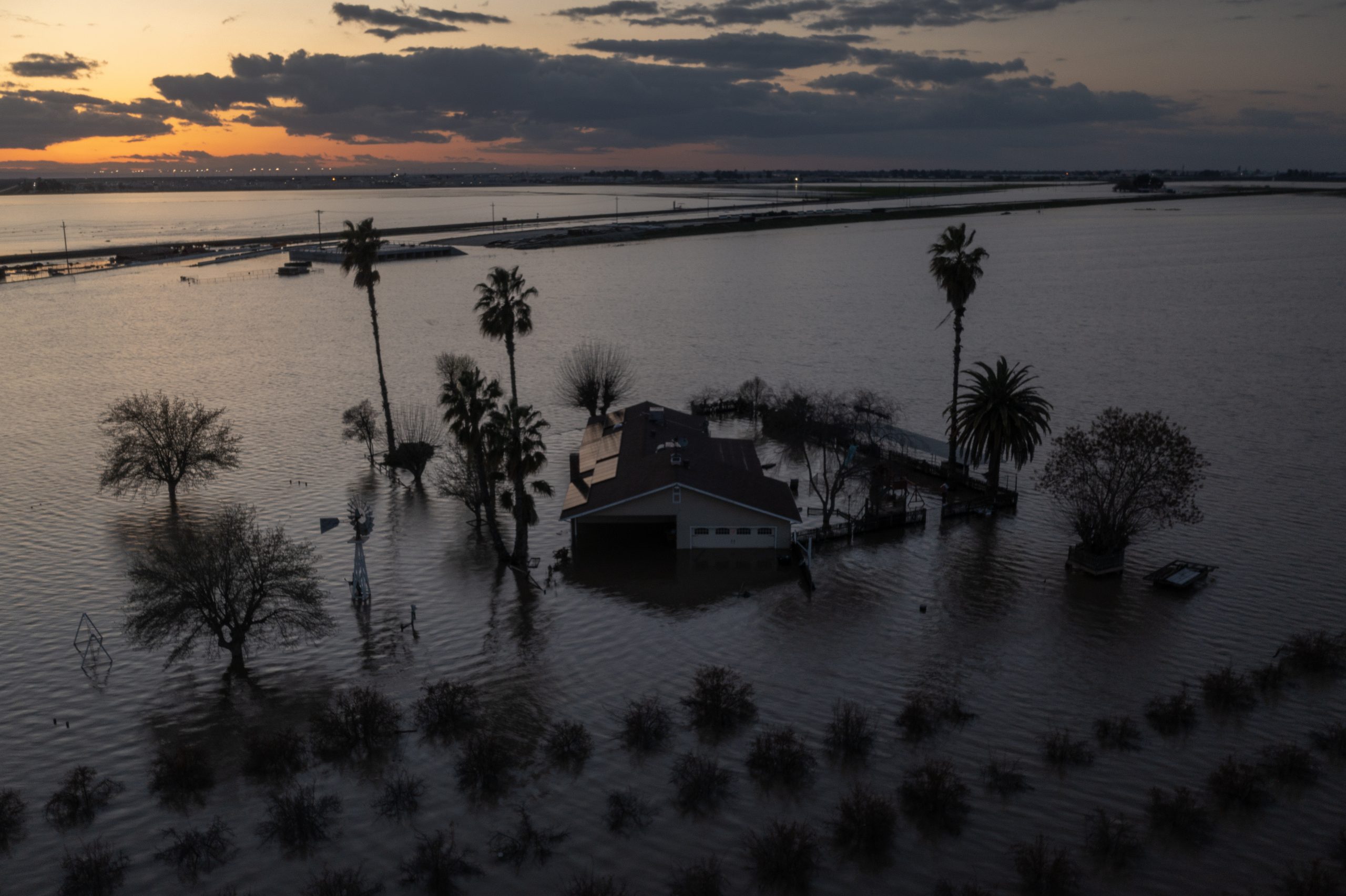 A house sits half submerged in flood water after a storm