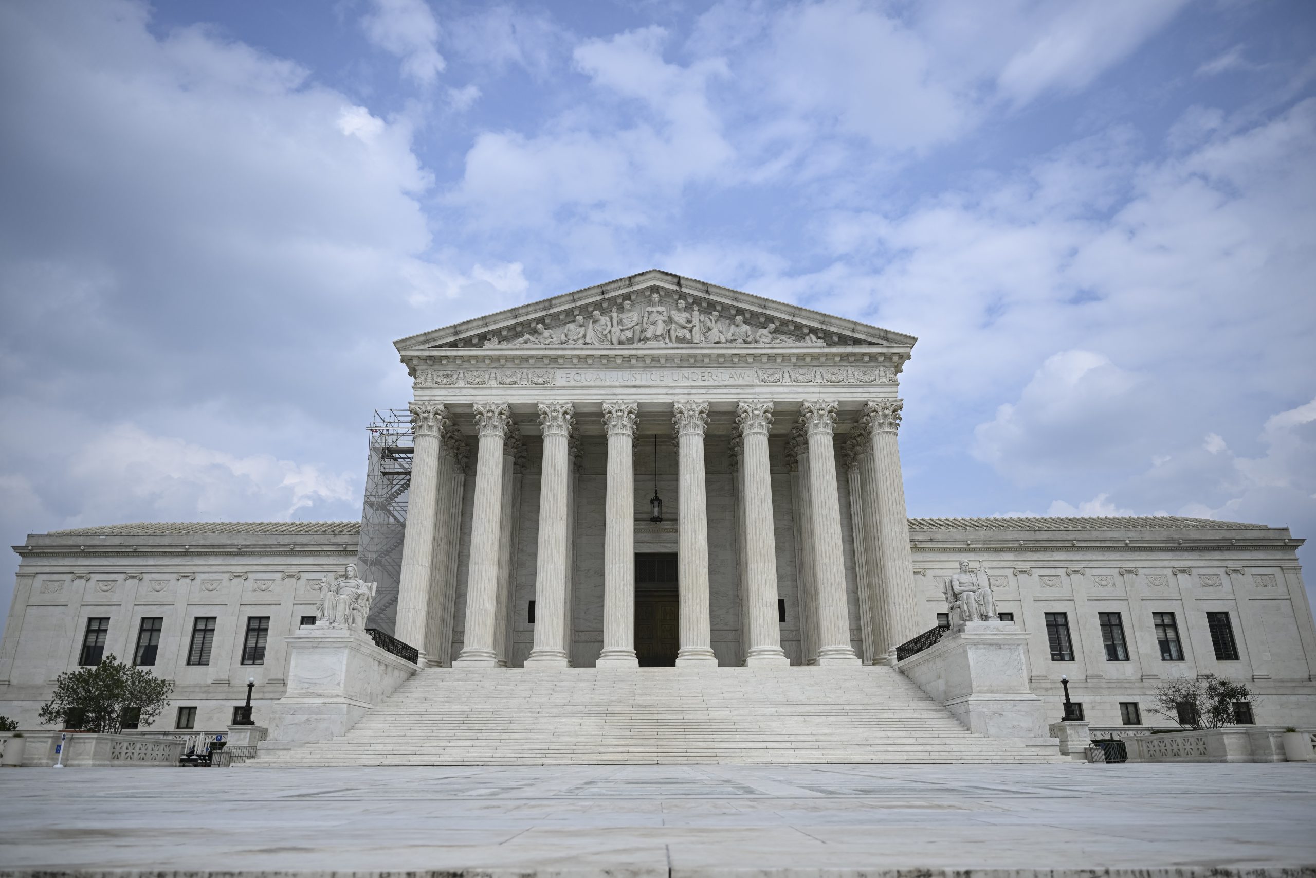 A look at the US Supreme Court. It has a white stone facade, numerous steps and several pillars.