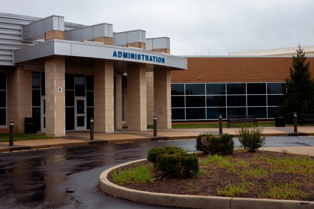 The glass-and-brick building says "Administration" over the front doors.