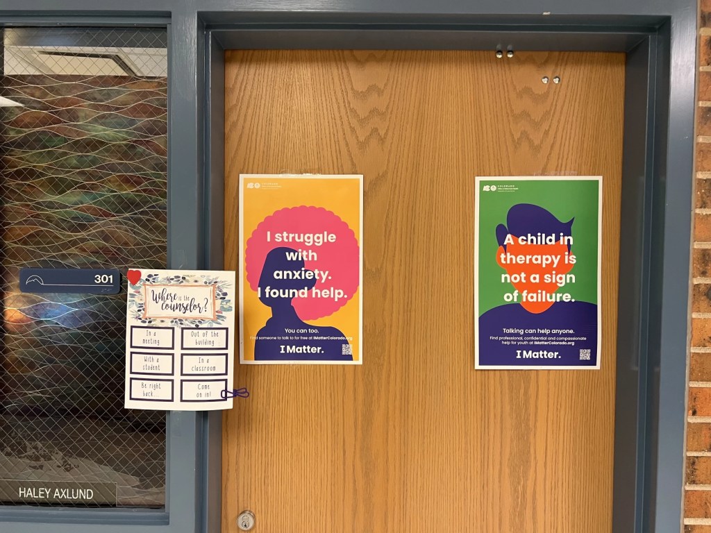 Counselor door at Fort Collins, Colorado high school. Posters on the door say "I struggled with anxiety. I found help" and "A child in therapy is not sign of failure."