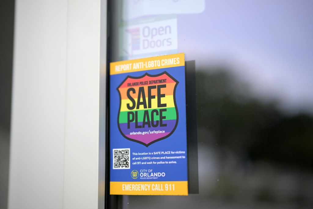 A sticker at the entrance of SPEKTRUM Healh reads, in part, "Report Anti-LGBTQ crimes. Orlando Police Department: Safe Place" is