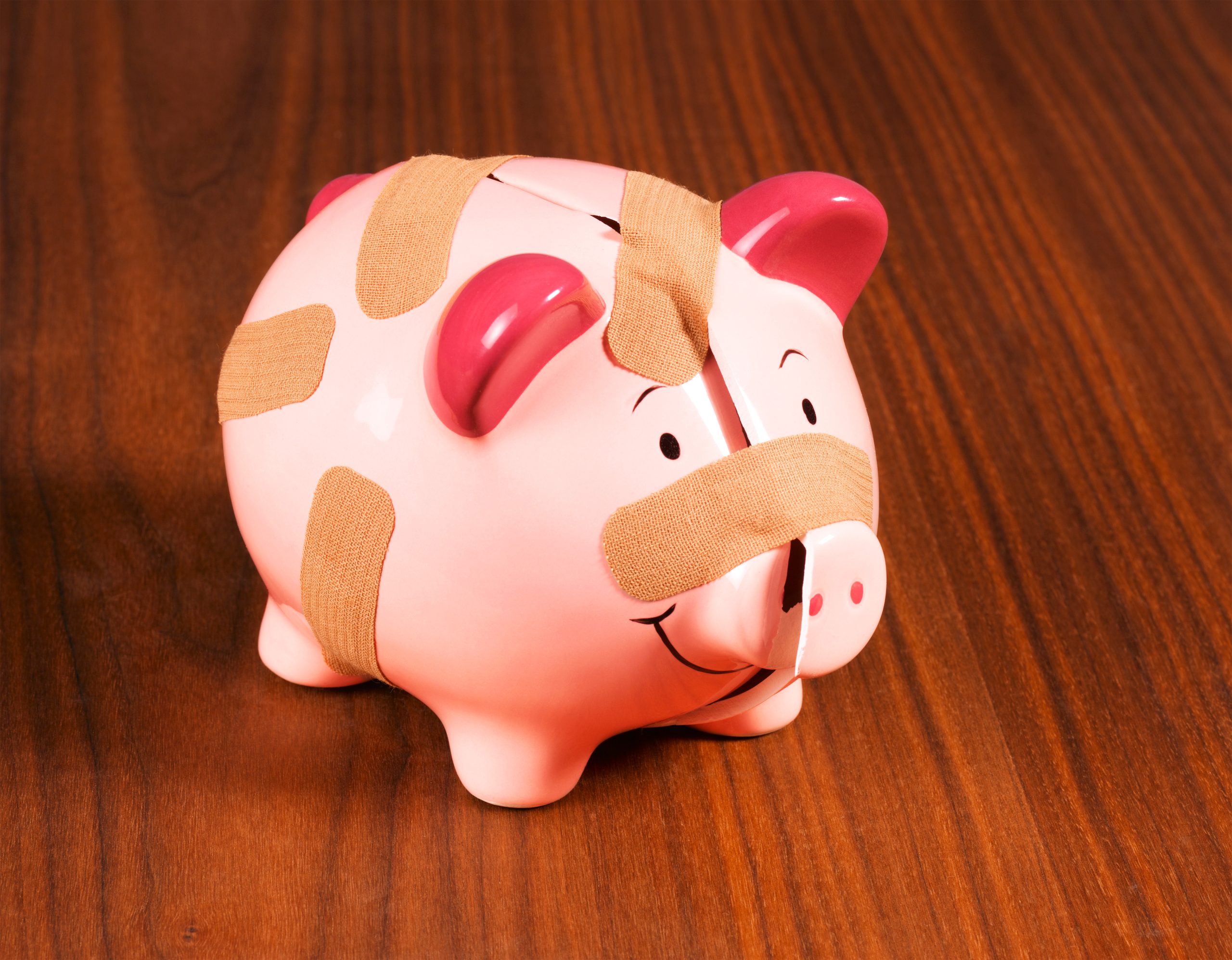 Cracked piggy bank with band aid