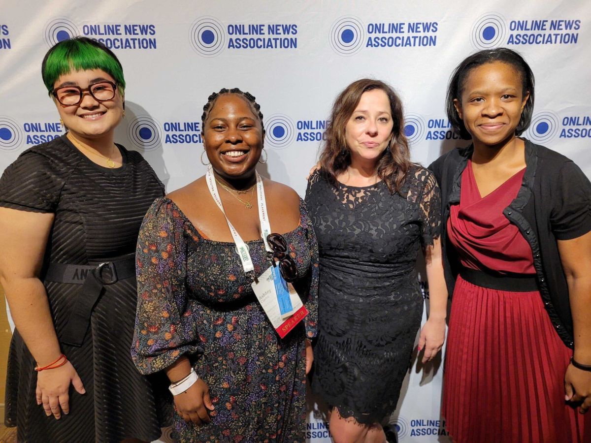 All three women are wearing dressy outfits and standing together, smiling